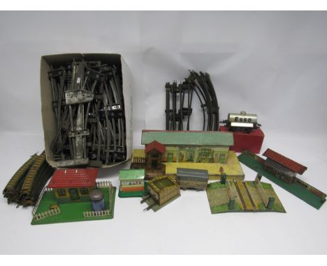 A collection of loose and playworn litho-printed 0 gauge model railway buildings and accessories including Issmayer (Germany)