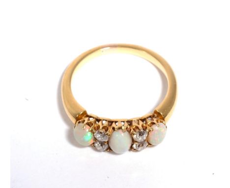 An opal and diamond ring, three oval cabochon opals, spaced by pairs of old cut diamonds, total estimated diamond weight 0.30