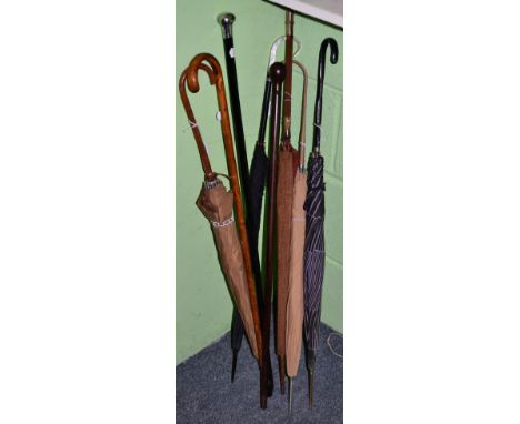 Lignum Vitae walking cane; a silver mounted cane; a 1930s parasol with horn handle and woven cover; walking stick and four um