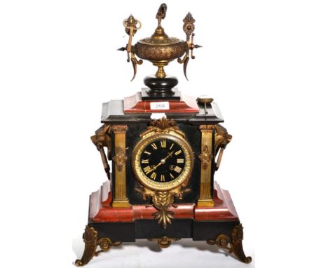 A Victorian red marble and black slate striking mantel clock