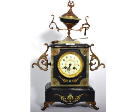 A Victorian onyx and slate striking mantle clock with urn surmount 