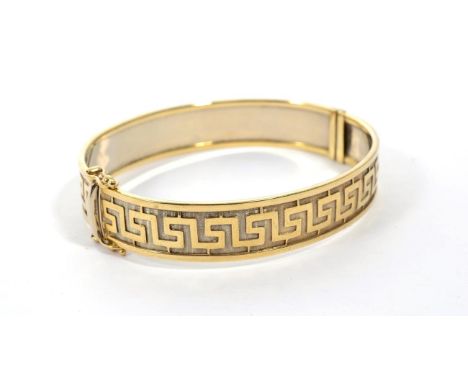 A 9 carat gold Greek key motif bangle, measures 6cm by 5.5cm 22.5g