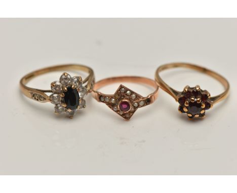 THREE YELLOW METAL RINGS, the first a garnet cluster ring, stamped gold, ring size O, a sapphire and cubic zirconia cluster r