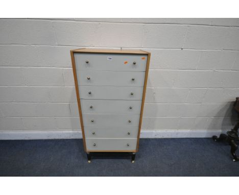 A MID CENTURY LIGHT OAK E-GOMME/G-PLAN BRANDON RANGE CHEST OF SEVEN DRAWERS, on ebonised legs width 61cm x depth 41cm x heigh