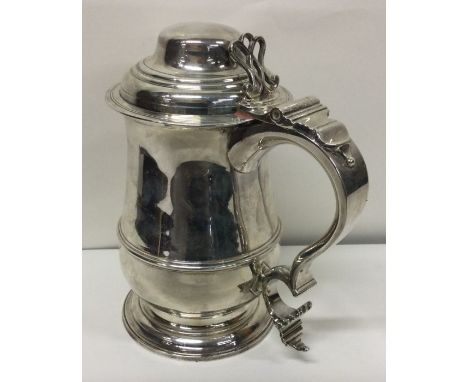 An 18th Century silver lidded tankard. London 1765. By John Moore. Approx. 932 grams. Est. £1500 - £2000.