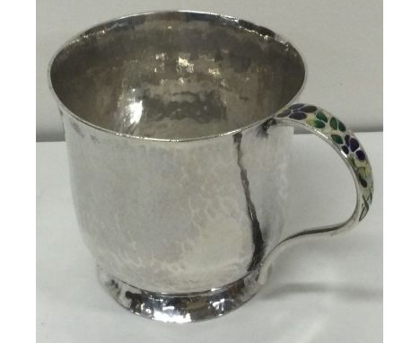 A novelty silver and enamel mug with hammered decoration. London 1927. By Bernard Instone. Approx. 102 grams. Est. £300 - £50