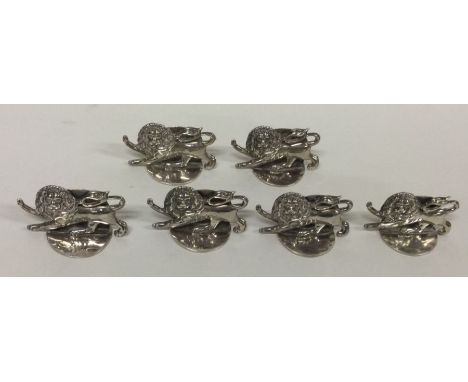 A set of six English silver menu holders in the form of lions. Approx. 70 grams. Est. £200 - £300.