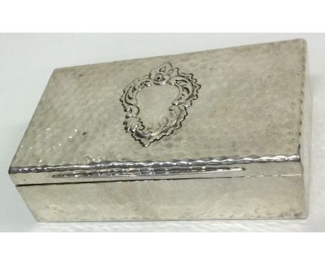 A silver snuff box of hammered design. London 1899. By Goldsmiths and Silversmiths. Approx. 151 grams. Est. £150 - £200.