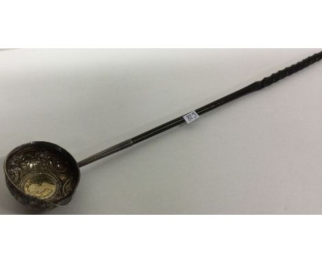 A Georgian silver toddy ladle inset with coin. Approx. 43 grams. Est. £20 - £30.