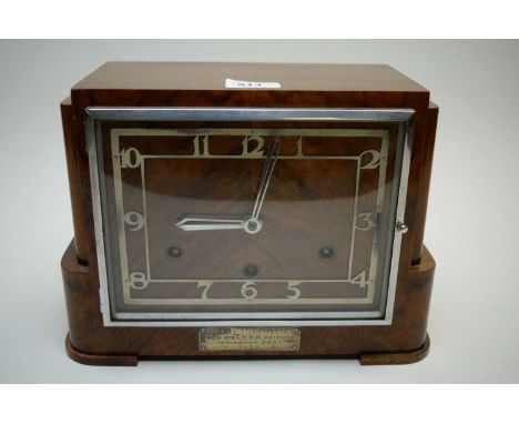 An Art Deco walnut cased mantel clock, the chrome arabic dial fitted a chiming movement.