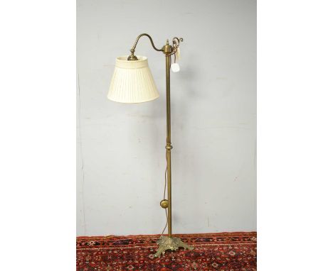 A 20th Century brass reading lamp, the central fluted brass column with scroll finial, raised on a foliate tripartite base, 1