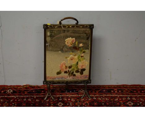 An Art Nouveau style brass firescreen, the central mirrored plate with painted roses contained within a stylized border, rais