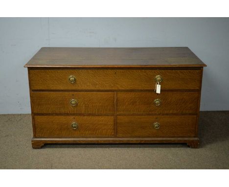 An early 20th Century oak chest of drawers, the rectangular top with moulded edge, above an arrangement of one long drawer an