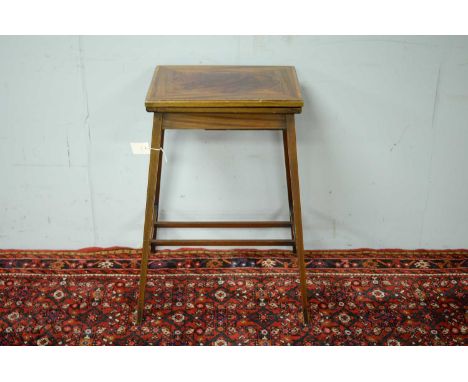 An Edwardian mahogany card table, the rectangular hinged top with inliad oval enclosing a baize lined playing surface, raised