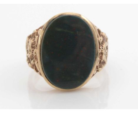 A gentleman's bloodstone signet ring, the oval bloodstone plaque measuring 20 x 14mm, flanked by leaf cast 9ct. yellow gold s