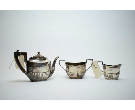 An American sterling standard silver three-piece bachelor's tea service, each piece of half-fluted form with engraved initial