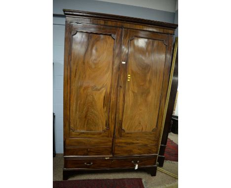 A Victorian mahogany two-door wardrobe, the projecting dentil moulded cornice above a pair of panel cupboard doors with dummy