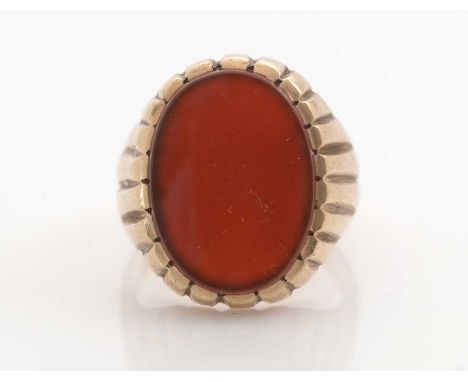 A gentleman's carnelian set signet ring, the oval carnelian plaque measuring 19 x 14mm, in a fluted 9ct. yellow gold mount an