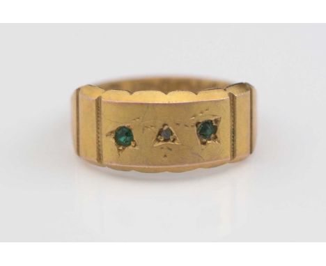 A Victorian 9ct. yellow gold ring, set with rose-cut diamond flanked by two green stones (probably emeralds), in a floral eng