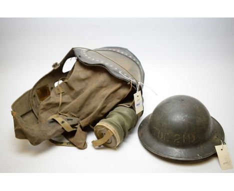 A WWII baby's gas mask, by P.S.C., dated 1939; together with a WWII Brodie-type helmet, stamped 'TDE219'.