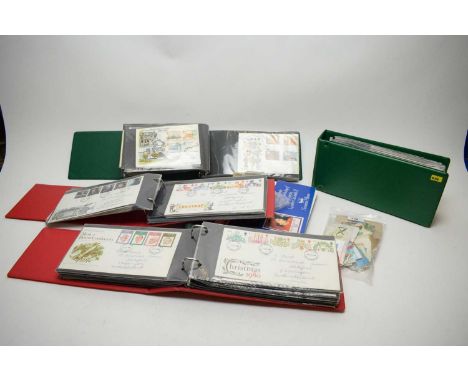 A collection of first day covers in four albums; a stamp album containing some Great Britain and World stamps including Canad