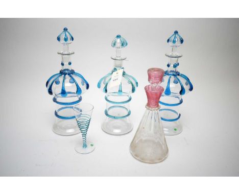 Three 19th Century clear glass decanters with trailed blue glass decoration (one cracked) each 30cms high; together with anot