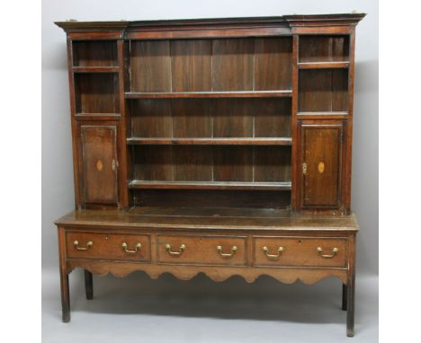 OAK DRESSER, 18th century and later, the three shelf plate rack with a pair of inlaid cupboards, the base with three frieze d