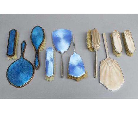 Enamel Dressing Table Items, comprising a four piece silver mounted peach enamel set, a three piece blue enamel silver mounte