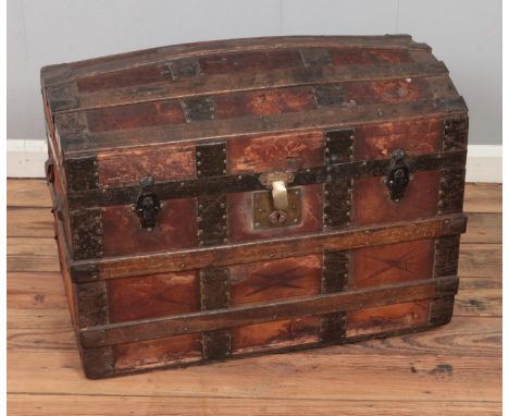 A wood-bound leather dome-top steamer trunk with geometric motifs. Hx55cmWx72cmDx43cm  