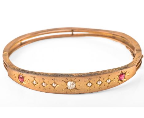 A Victorian yellow metal ruby and diamond bangle, set to centre with a cushion shape old mine diamond with an approximate wei