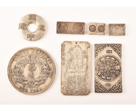 A collection of Chinese white metal ingots, one tablet decorated with the Chinese Zodiac and dragons, another with a Chinese 