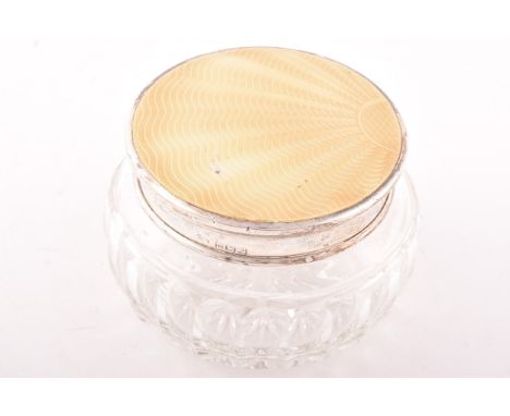 A cut crystal dressing table pot with silver lid, hallmarked for Birmingham 1914 by Adie Brothers Ltd, with inlaid yellow ena