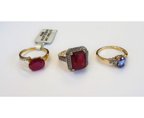 A 9ct gold, red and colourless gem set rectangular cluster ring, a 9ct gold oval cut treated ruby and colourless gem set ring