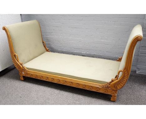 An early 20th century European day bed, the outswept arms mounted with swans head finnials over carved frieze, 220cm wide x 1