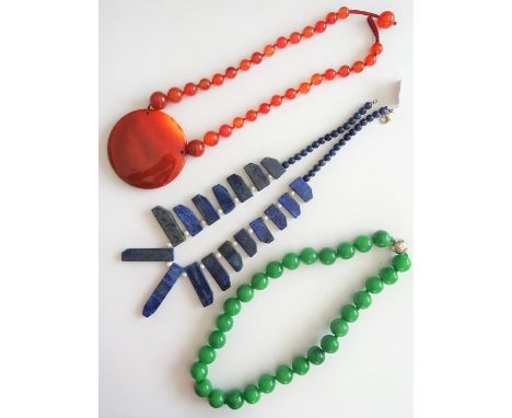 A single row necklace of treated green stone beads, a cornelian necklace, the front with a circular panel pendant between row