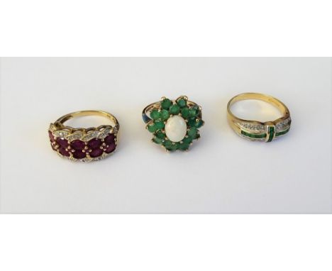 A 9ct gold, emerald and diamond ring, mounted with two rows of calibre cut emeralds and otherwise set with small circular cut