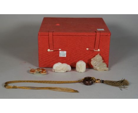 A group of Chinese jades, comprising; a celadon and russet jade carving of a bat and cash, 4.5cm. wide; a white jade group of