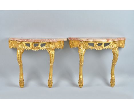 A pair of 19th century console tables, each with serpentine marble top,over carved and pierced frieze on pair of opposing 'C'