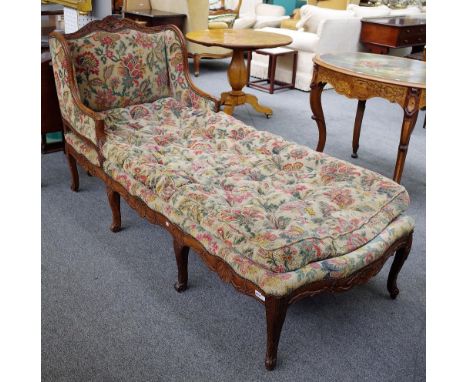 An 18th century and later French carved oak framed wing back day bed, with shell carved frieze on eight scroll supports. 