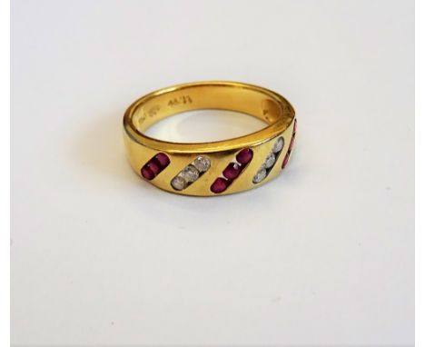 A gold, ruby and diamond ring, mounted with three rows of three circular cut rubies, alternating with two rows of three circu