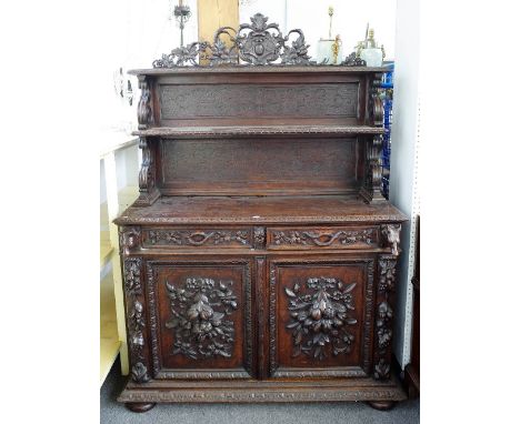 A 19th century Germanic carved oak side cabinet, the two tier  shelf back over a pair of drawers and cupboards, stamped to dr