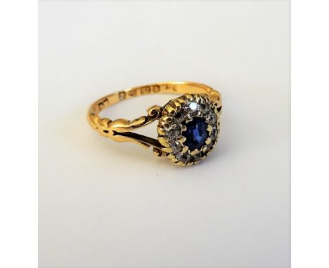 A late Victorian 18ct gold, sapphire and diamond set oval cluster ring, mounted with the oval cut sapphire to the centre, in 