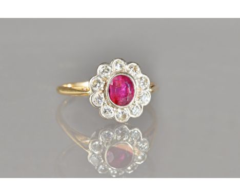 A gold, ruby and diamond set oval cluster ring, collet set with the oval cut ruby to the centre, in a surround of ten circula