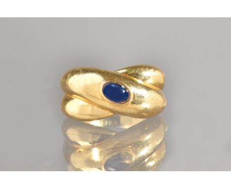 A Cartier gold and cabochon sapphire single stone ring, in a twistover design, mounted with an oval cabochon sapphire, detail