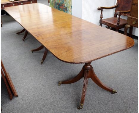 A Regency style mahogany triple pillar extending dining table, on twelve downswept supports, two extra leaves, 101cm wide x 2