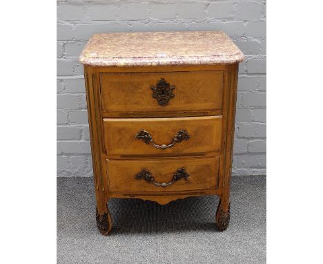An early 20th century Continental petit commode, the marble top over a gilt metal mounted walnut three drawer base, on shaped