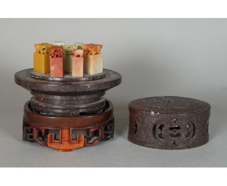 A Chinese brown soapstone seal container and seven seals, 20th century, the cover carved with two confronting dragons, the si