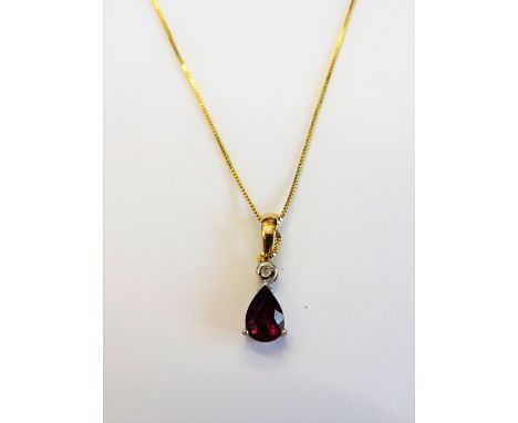 A 9ct gold, ruby and diamond pendant, claw set with a pear shaped ruby below and with a circular cut diamond above, on a 9ct 