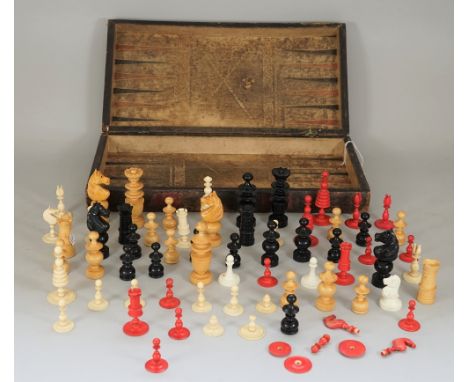 A Victorian folding chess and backgammon board, detailed as a leather bound book, 43cm wide, containing a carved wooden chess