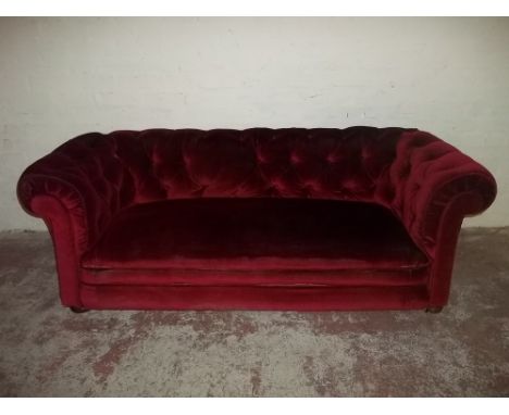 A RED UPHOLSTERED BUTTON BACK SOFA